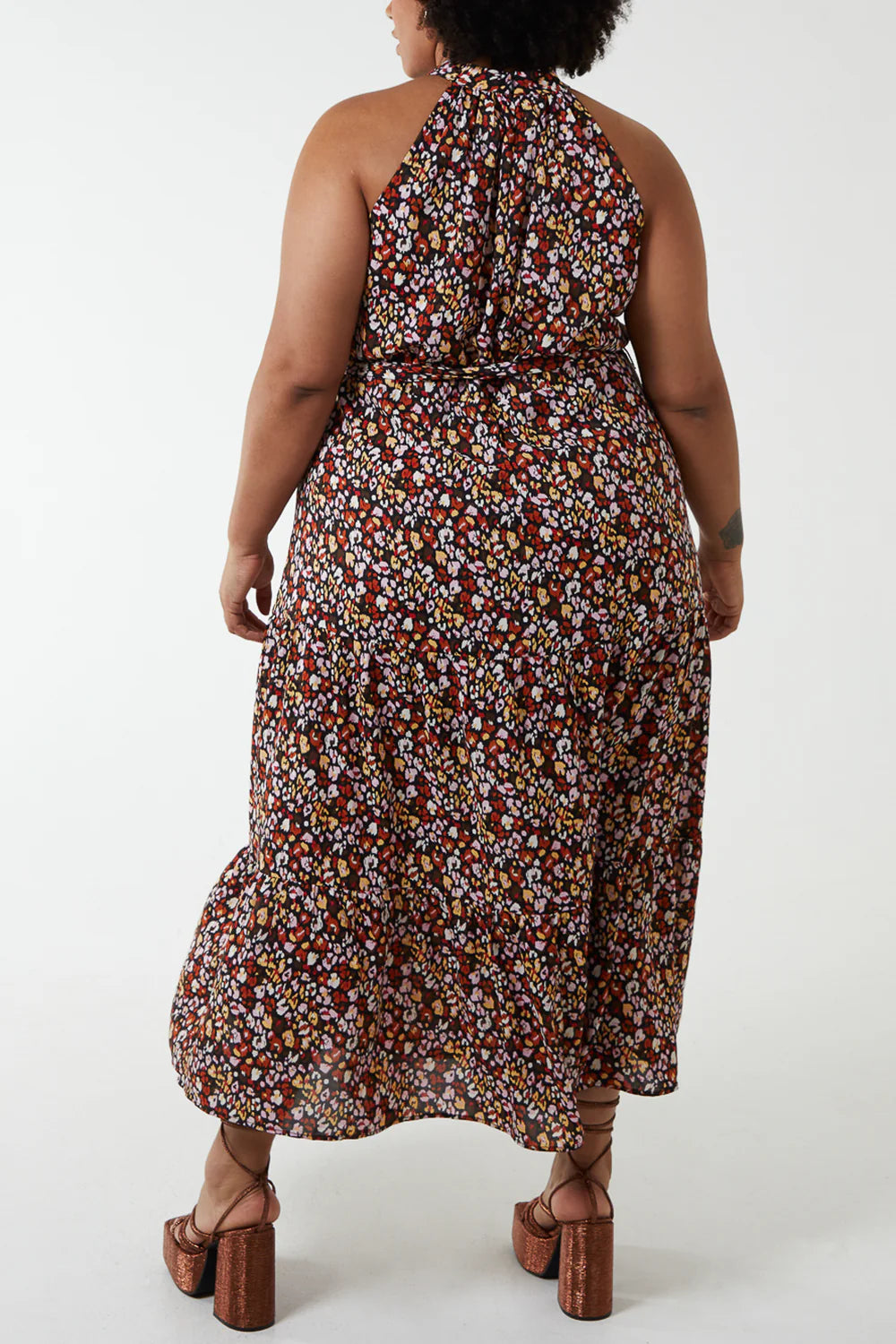 Vibrant leopard print maxi dress with a halter neck, showcasing a flowing, elegant silhouette for plus-size fashion.