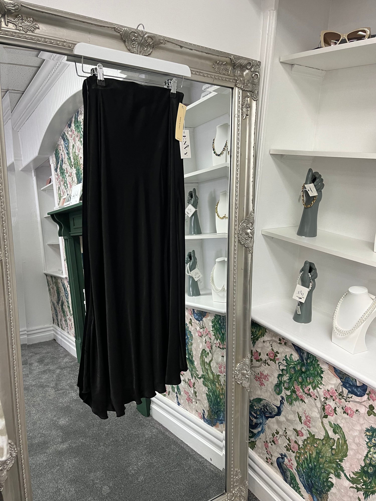 Elegant black silky skirt with a smooth, flowing fabric, designed to fit sizes 8-14/16 for a versatile, chic look.