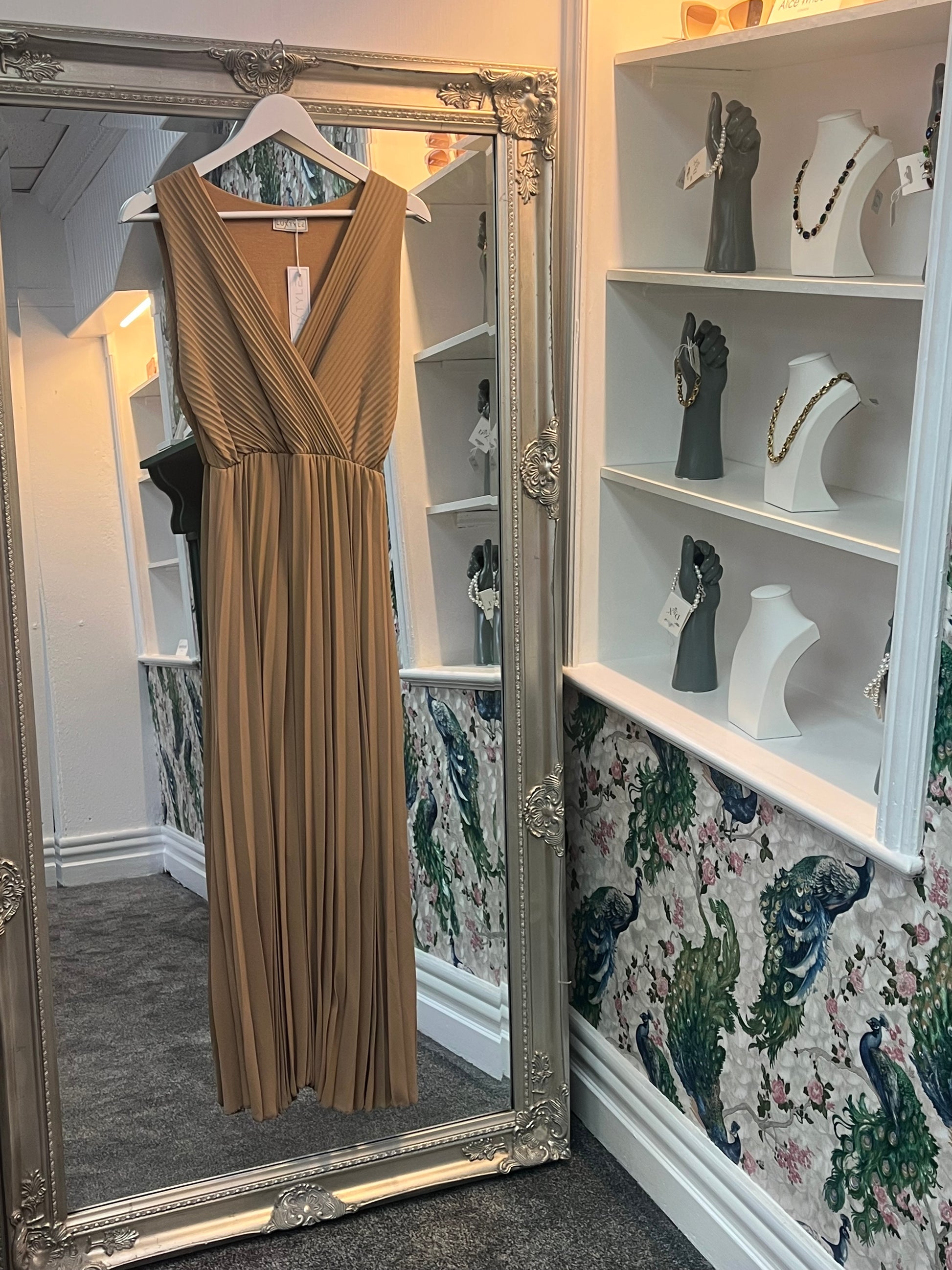Elegant latte-colored pleated sleeveless dress, designed to flatter sizes 8-14 with a flowy, chic silhouette.