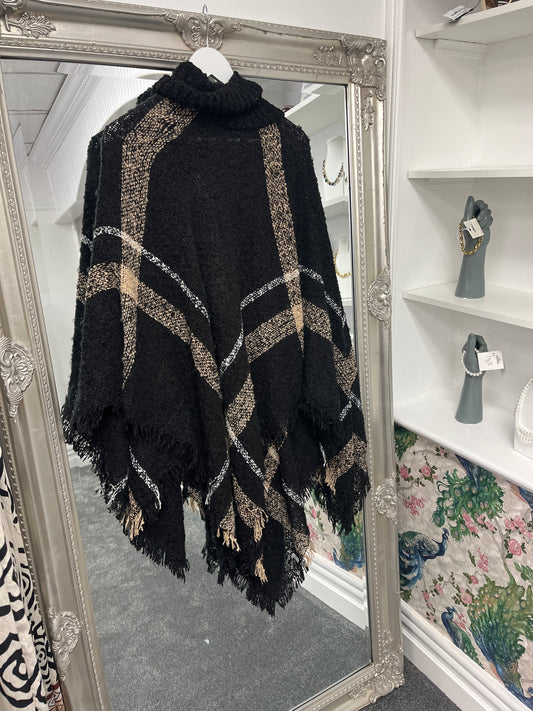 Cozy curve roll neck check poncho in a stylish black and white pattern, perfect for layering over any autumn outfit.
