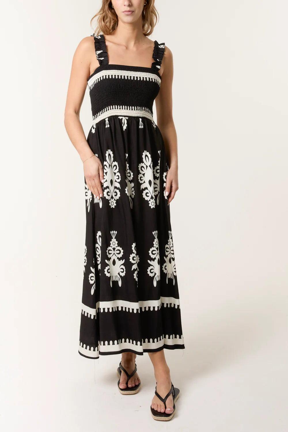 Elegant black maxi dress with a shirred bodice and vibrant print, crafted from a soft viscose-polyester blend for comfort.