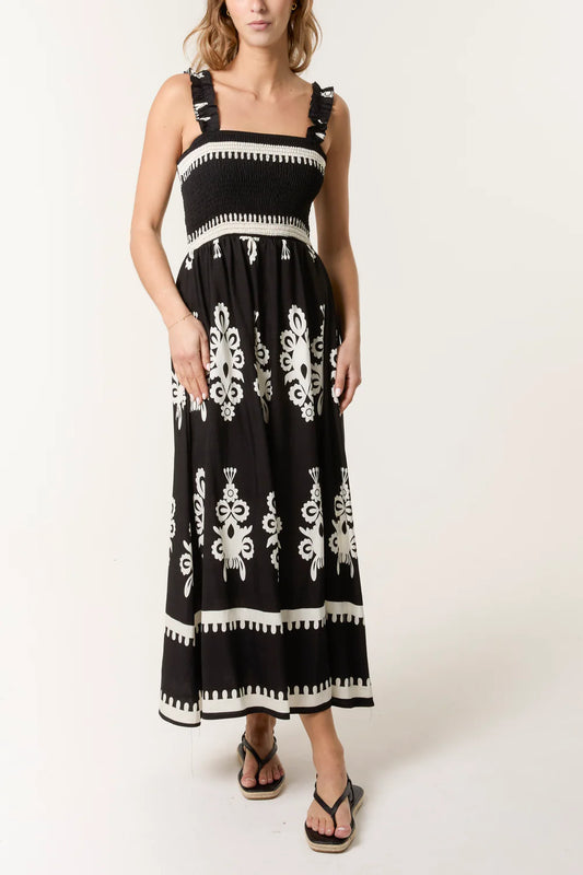 Stylish black halterneck jumpsuit with a shirred bodice and vibrant print, crafted from a soft viscose-polyester blend.