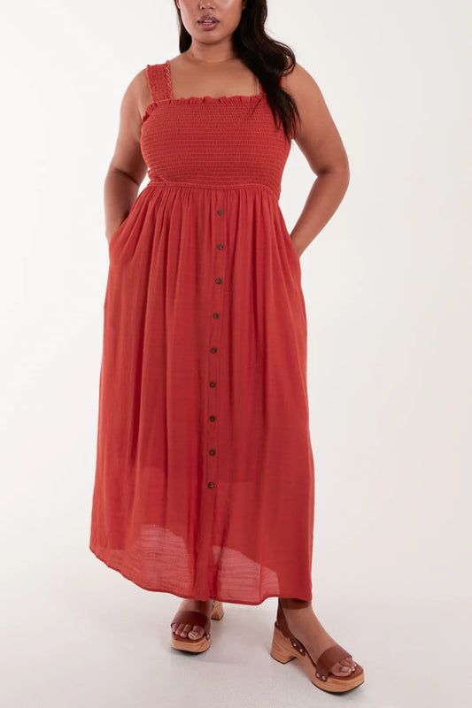 Elegant plus-size maxi dress in lightweight fabric with a shirred bust, thin straps, and stylish wooden buttons down the front.